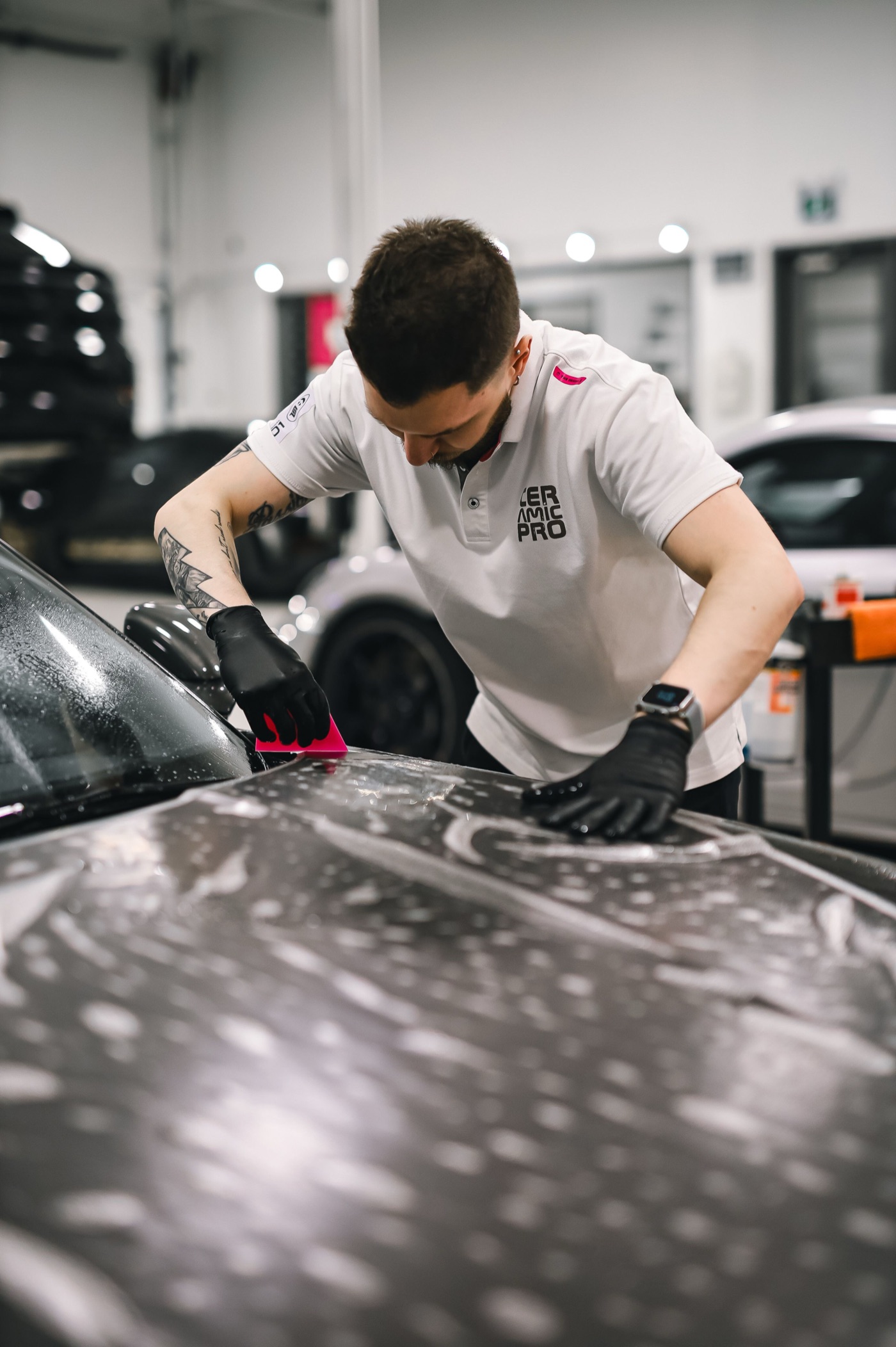 Profissional de estética automotiva aplicando película em um carro